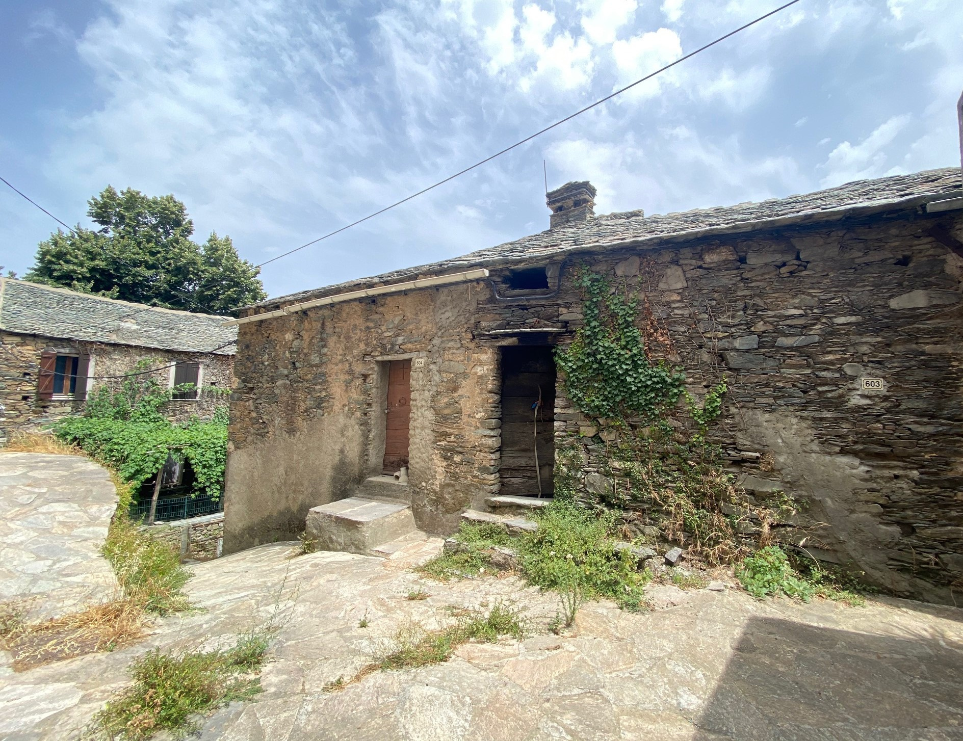 Maison de village mitoyenne, en pierre et toit en lauze avec cave, à rénover.