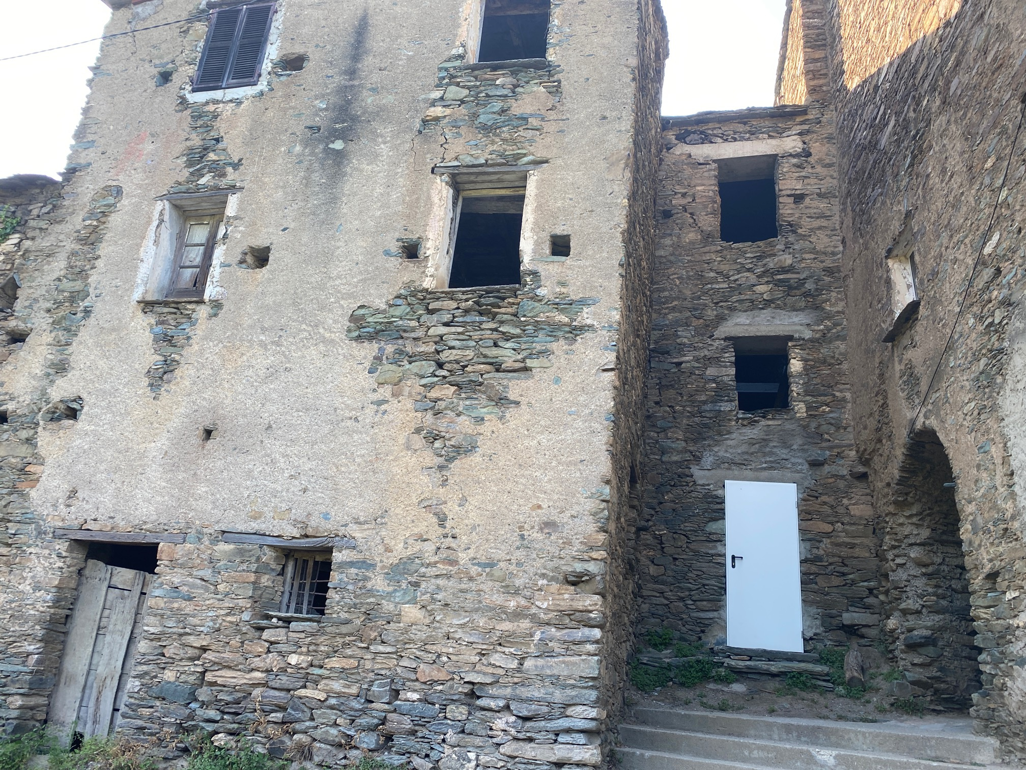 Maison de village mitoyenne, en pierre et toit en lauze avec cave, à rénover.