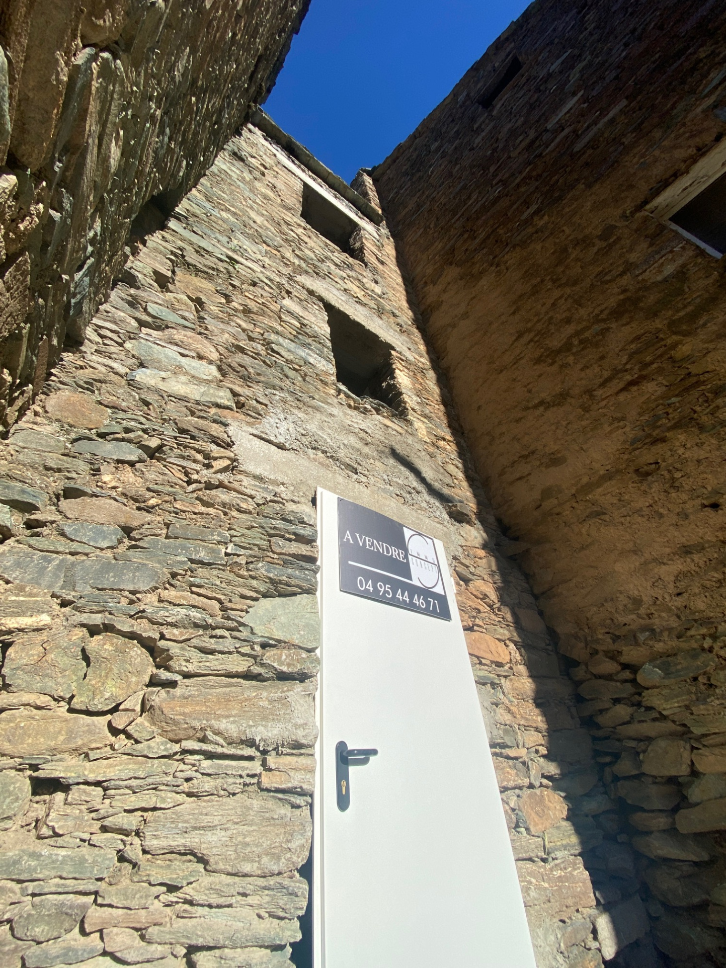 Maison de village mitoyenne, en pierre et toit en lauze avec cave, à rénover.