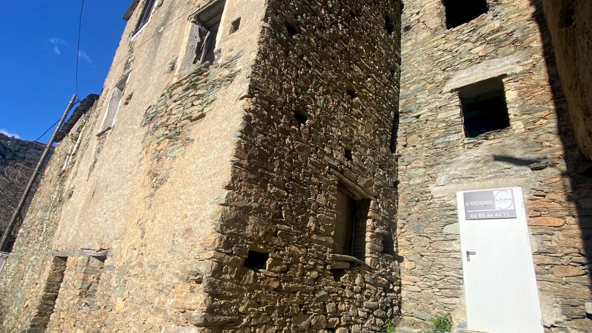 Maison de village mitoyenne, en pierre et toit en lauze avec cave, à rénover.