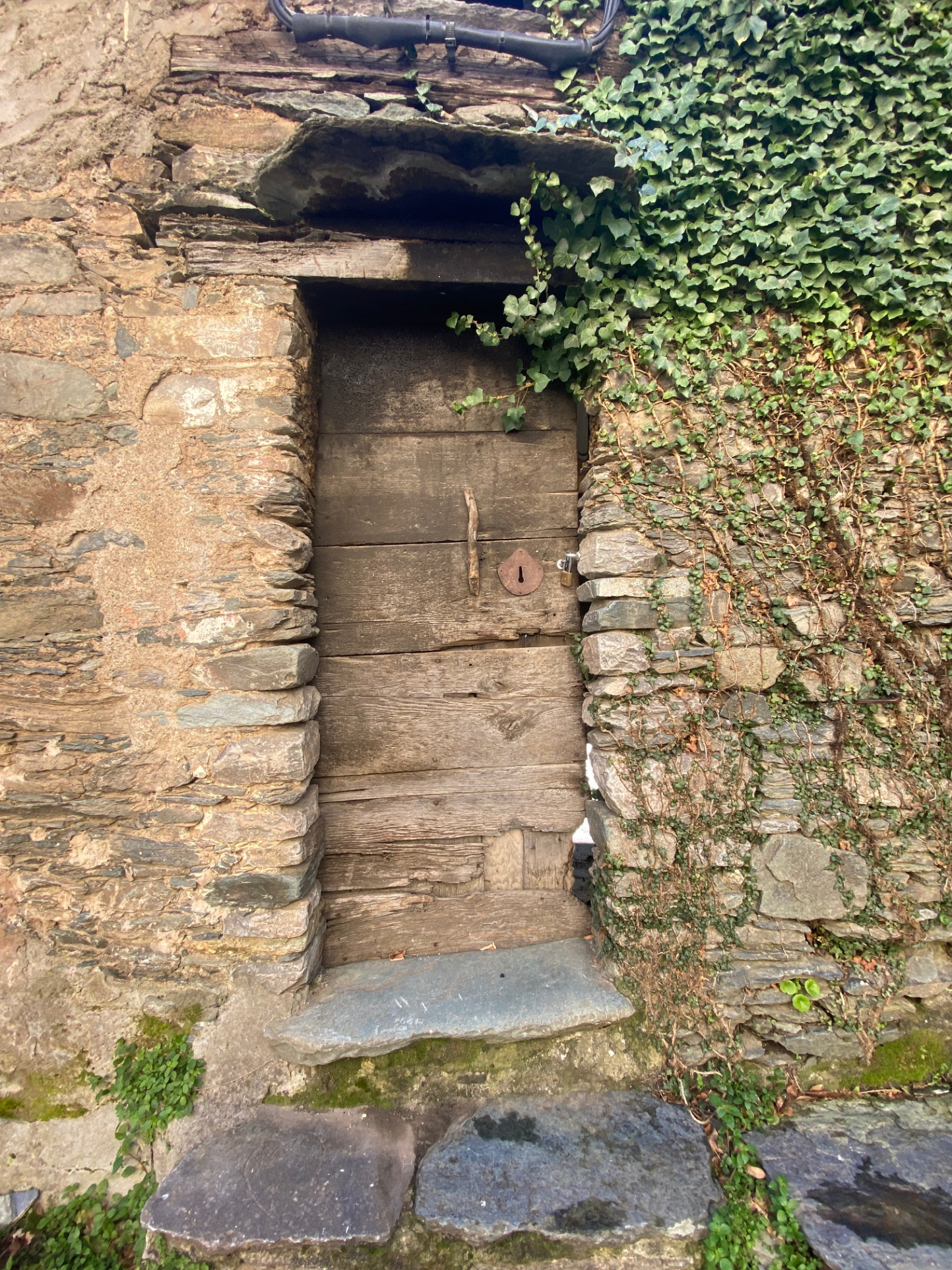 Maison de village mitoyenne, en pierre et toit en lauze avec cave, à rénover.