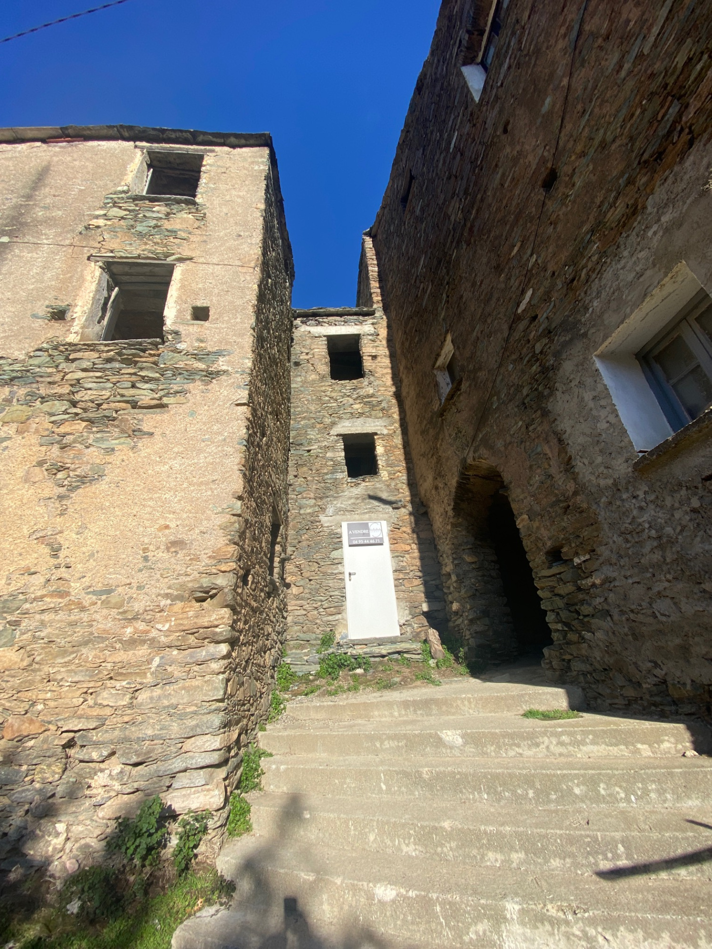 Maison de village mitoyenne, en pierre et toit en lauze avec cave, à rénover.